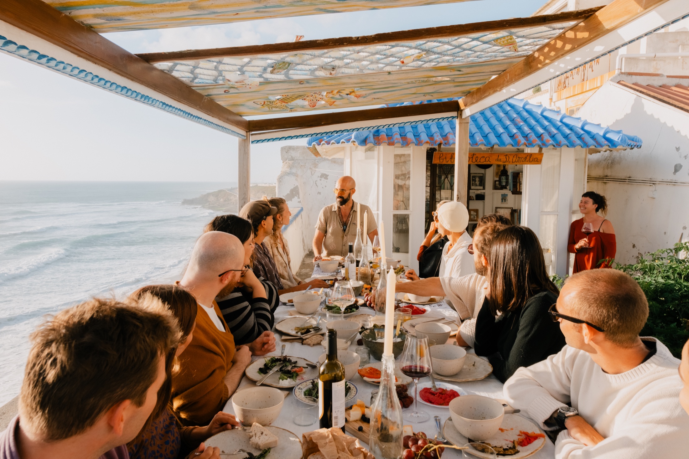 Guests sharing dinner above the sea in Ericeira